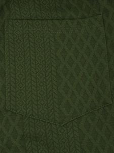 Detail of dark green trousers showing geometric jacquard texture and pocket design