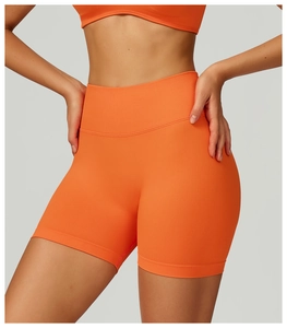 Dettaglio degli shorts da yoga arancioni senza cuciture con vita alta e texture a coste
