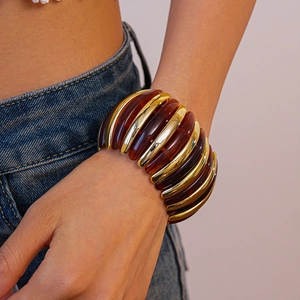 Macro detail of amber resin and gold metal beads on a stylish elastic bracelet