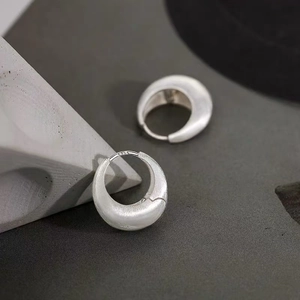 Close-up of minimalist S925 sterling silver geometric stud earrings with matte finish