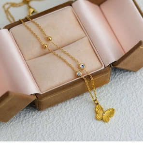 Macro detail of golden butterfly pendant with bead edge and crystal on chain