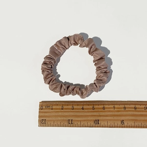 Dettaglio dell'elastico in raso champagne con righello che mostra il diametro di 6cm