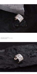 Macro detail of vintage wide silver ring with floral engravings and white gemstone