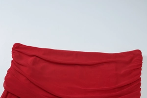 Close-up of red mesh fabric showing detailed texture and elastic draping on the dress