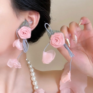 Detailed view of pink fabric rose earrings with delicate tassels and silver needles