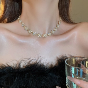 Gros plan d'un collier choker doré serti de zircons porté par un mannequin