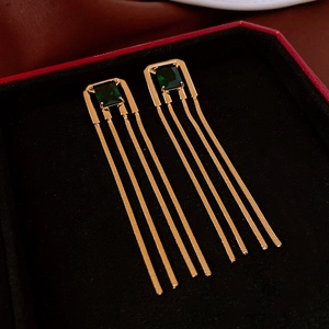 Detail of emerald green tassel earrings with square zircon in a luxury velvet box