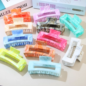 Detailed top view of various marble pattern hair claws in multiple vibrant colors