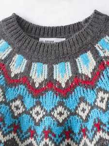 Detail of the crew neck collar and blue geometric jacquard knit pattern on the gray sweater