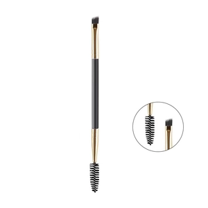 Close-up of double-ended eyebrow brush with angled bristles and spiral spoolie detail