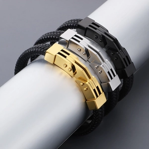 Dettaglio di bracciali in pelle intrecciata con chiusure magnetiche in oro, argento e nero