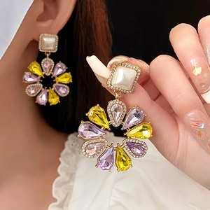 Details von Vintage-Blumen-Ohrringen mit lila Kristallen und funkelnden Diamanten