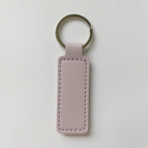 Detail shot of light pink rectangular PU leather keychain with silver metal ring and stitching
