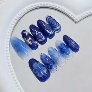 Handmade almond press-on nails with blue butterfly patterns and starry sky gradient design