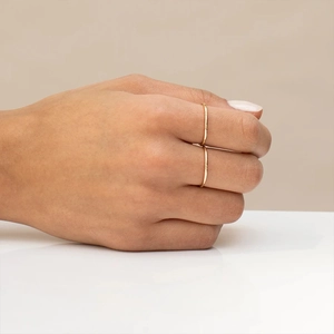 Close-up of minimalist layered golden S925 silver rings worn on a hand model