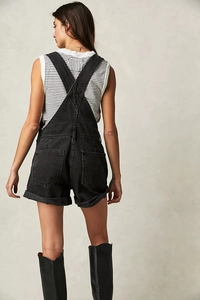 Rear view of loose fit black washed denim overalls with multiple pockets and hem detail