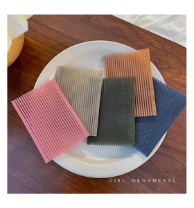 Close-up of five colorful nylon hair gripper pads neatly arranged on a ceramic dish