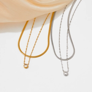 Detail of double-layer snake chain bracelet with sparkling zircon in gold and silver finish