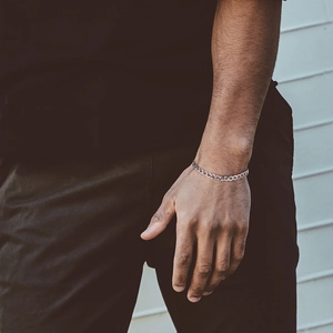 Close-up of a men's 925 sterling silver Cuban link chain bracelet on a wrist