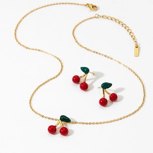 Golden stainless steel jewelry set featuring red cherry pendant necklace and stud earrings