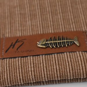 Brown ribbed knit beanie featuring an HS FASHION leather patch and fishbone charm