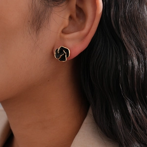 Detail of vintage black rose stud earrings with gold trim on model ear for display