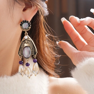 Detailed view of vintage crystal tassel earrings with grey-purple gemstones and drops
