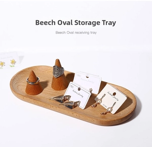 Macro view of natural beech wood oval tray with two conical ring holders for jewelry storage