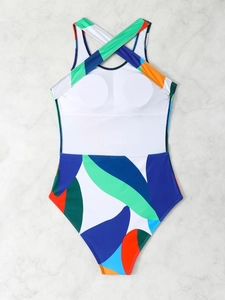 Detail view of cross-back straps and abstract geometric patterns on a one-piece swimsuit