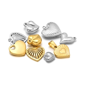 Macro shot of 18K gold and silver heart charms in various textures and polished finishes