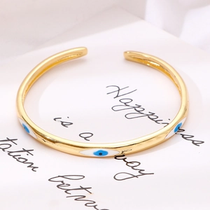 Dettaglio del bracciale rigido a C placcato in oro con occhio in smalto blu