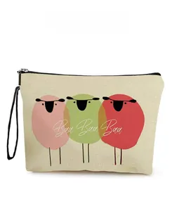 Détail de la trousse de maquillage en toile avec moutons colorés et dragonne noire