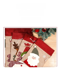 Close-up of linen Christmas drawstring gift bags with Santa and reindeer embroidery