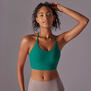 Detail of emerald green sports bra with thin straps and supportive wide underband