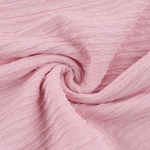 Close-up detail of pink elegant pleated fabric texture with soft wavy folds