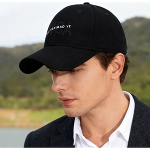 Detailed view of black cotton baseball cap with white embroidery and six-panel structure