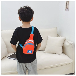 Vue arrière du sac bandoulière enfant en nylon orange avec sangle bleue en décor intérieur