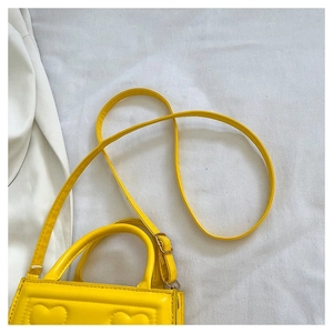 Détail du sac à main jaune avec matelassage en cœur et bandoulière réglable chic