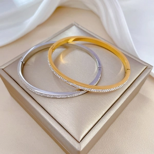 Detail of elegant gold and silver titanium steel bracelets with pavé rhinestones