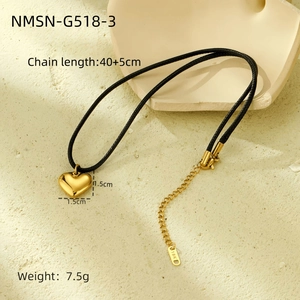 Macro shot of 18K gold heart pendant with black cord on geometric stone display