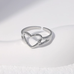Close-up of silver hollow heart stainless steel open ring with delicate bead details