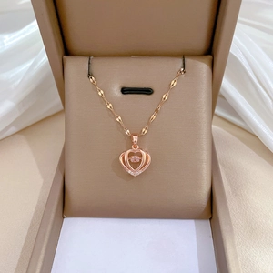 Close-up of rose gold heart necklace with pink zircon in a beige jewelry box