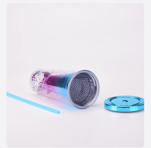 Flat lay of double-layered plastic tumbler with mermaid tail design and blue straw