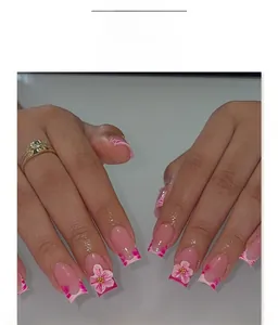 Close-up of pink French press-on nails with 3D floral accents and zebra stripe details