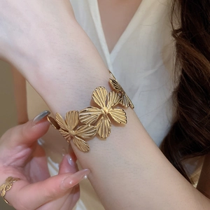 Dettaglio di set gioielli vintage con fiori dorati e petali metallici testurizzati