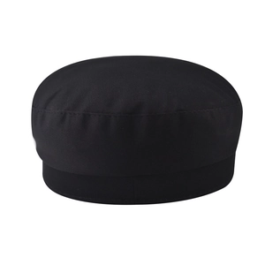 Detailed close-up of a black cotton newsboy cap featuring a flat top and twin-needle stitching