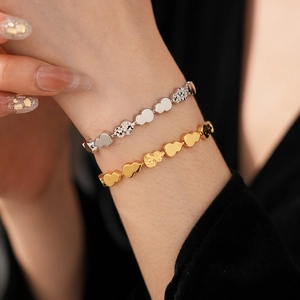 Macro shot of stacked gold and silver gourd chain bracelets showing polished textures