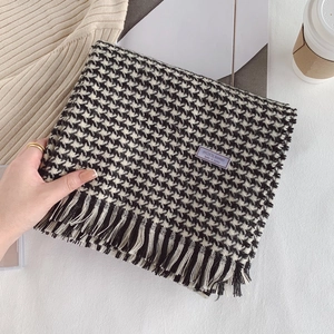 Close-up of wool blended houndstooth scarf with elegant fringes and brand labels