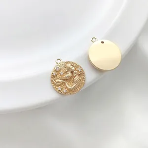 Detailed view of 14K gold mermaid relief charm with sparkling zircon stone accents