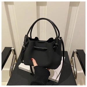 Detail of soft black PU leather bucket bag with drawstring closure and hand touch texture